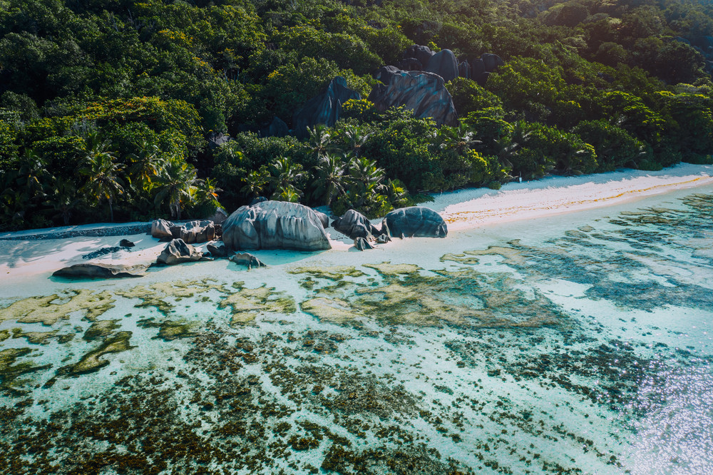 Aerial view of bay with shallow water on early morning of unique Anse Source D\'Argent tropical beach, La Digue Seychelles. Luxury exotic travel concept