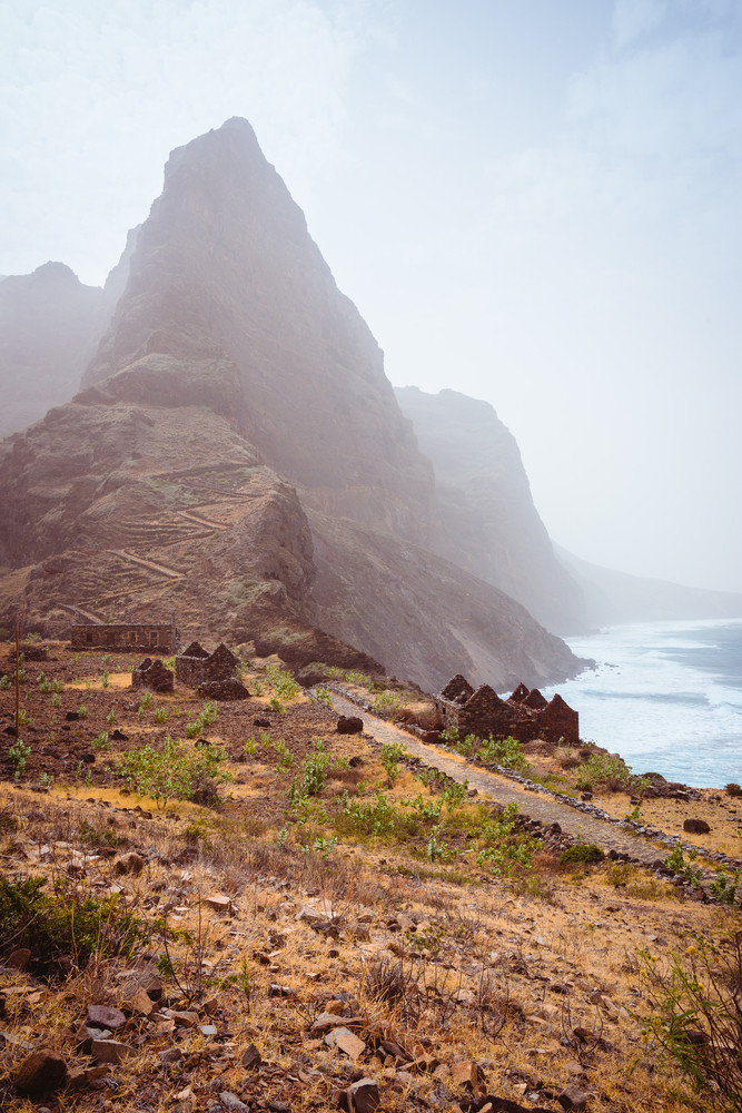Aranhas mountain peak in the valley with house ruins and stony hiking path going up the mountain from Ponta do Sol to Cruzinha village. Santo Antao Island, Cape Verde