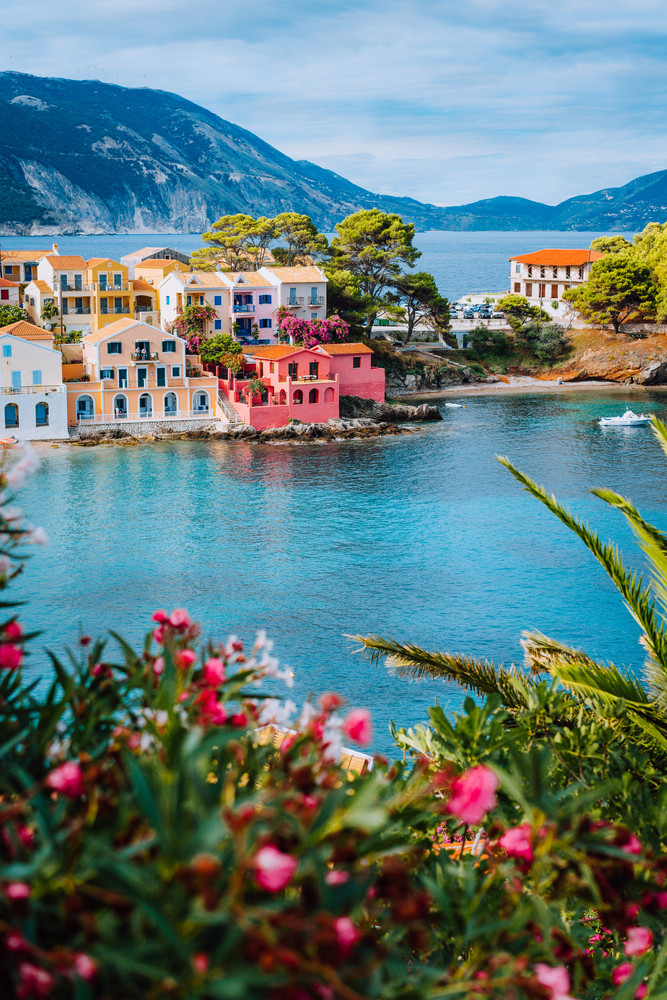 Beautiful view of Assos village with vivid colorful houses near blue turquoise colored and transparent bay lagoon. Kefalonia, Greece