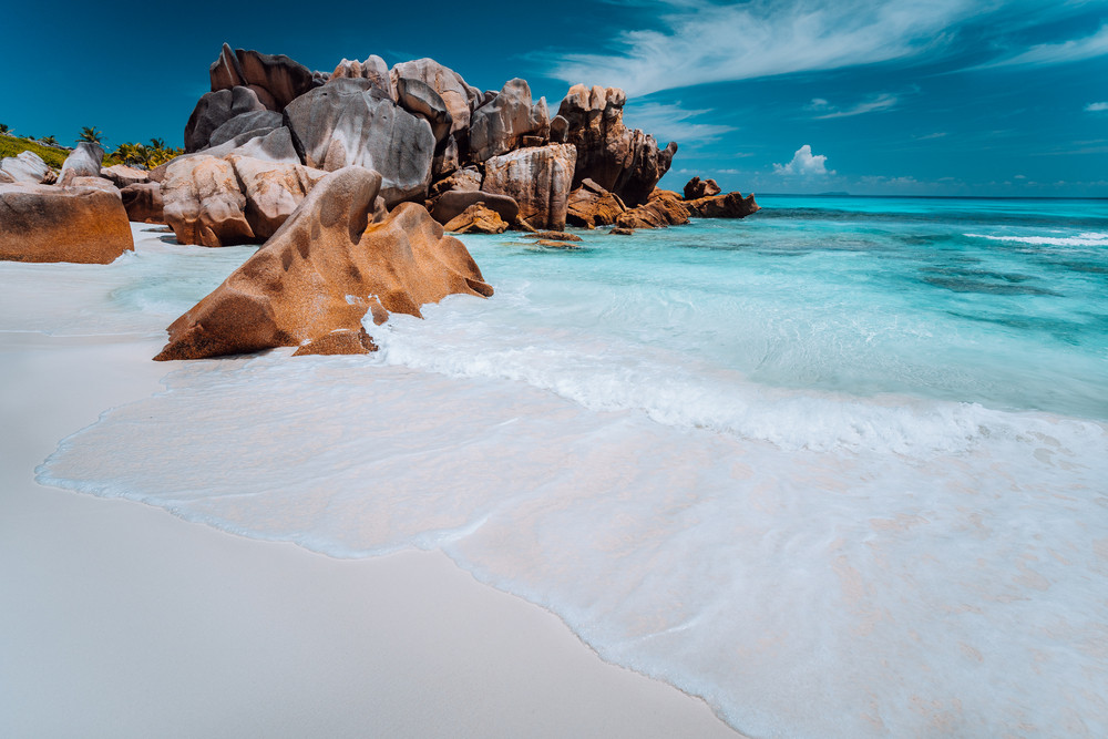 Granite rocks boulders, perfect white sand, turquoise water, blue sky. paradise beach Anse Cocos on the Seychelles. Vacation background