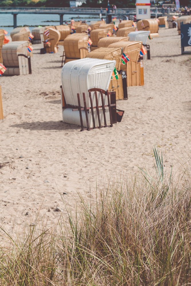 Roofed wooden chairs on sandy sea beach. German travel. Travemunde, Germany