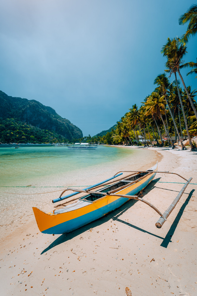 Traditional wooden banca boat on beautiful Las Cabanas beach. Summer vacations, Island hopping, El Nido, magic of Philippines