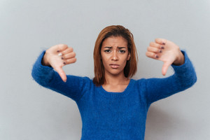 graphicstock-displeased-young-african-woman-in-sweater-showing-thumbs-down-isolated-gray-background_H8YXw_m_hg_thumb.jpg