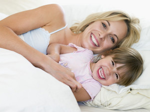 Woman And Young Girl In Bed Smiling Royalty Free Stock Image