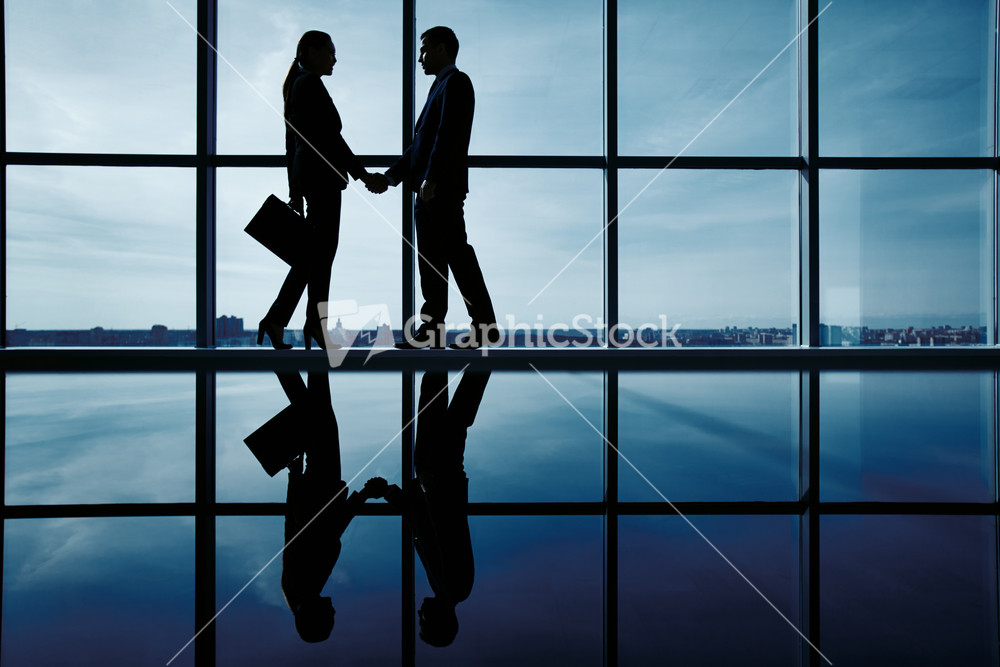 Outlines Of Two Business Partners Handshaking By The Window