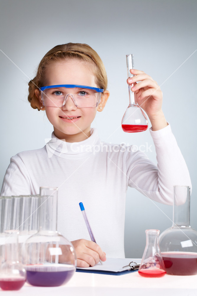 Vertical Shot Of A Cute Little Girl Writing Down The Results Of Her Scientific Experiment