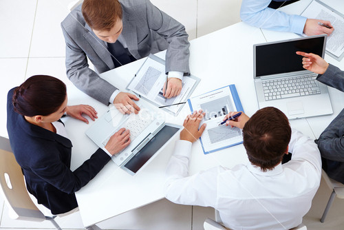 Above View Of Business Team Sitting Around Table And Working