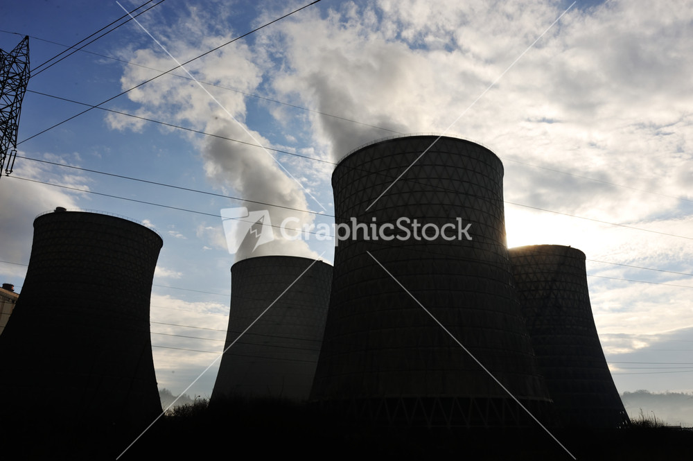 Coal fired power station with cooling towers releasing steam into atmosphere