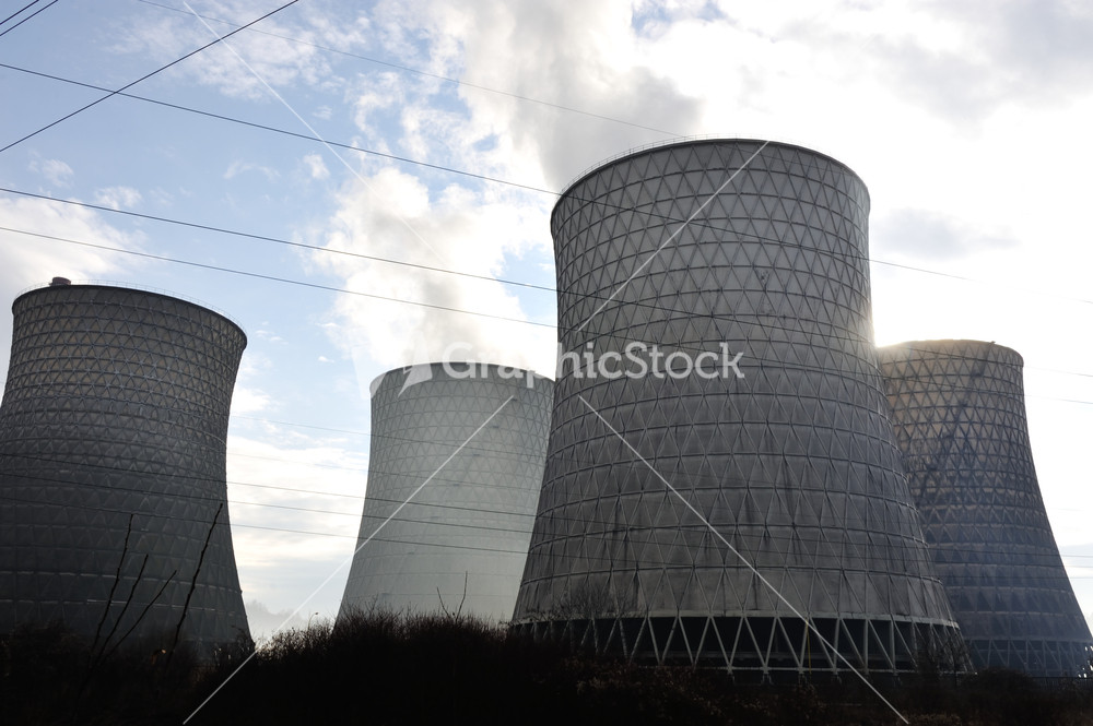 Coal fired power station with cooling towers releasing steam into atmosphere