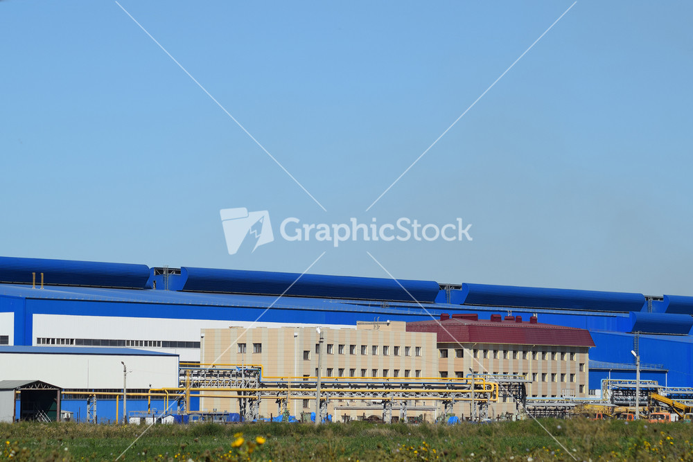Big plant for processing scrap metal. huge factory old metal refiner. blue roof of the factory building. exhaust pipes