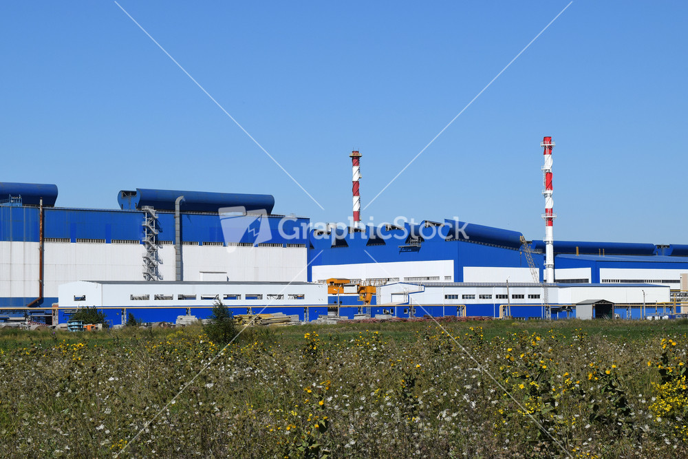 Big plant for processing scrap metal. huge factory old metal refiner. blue roof of the factory building. exhaust pipes
