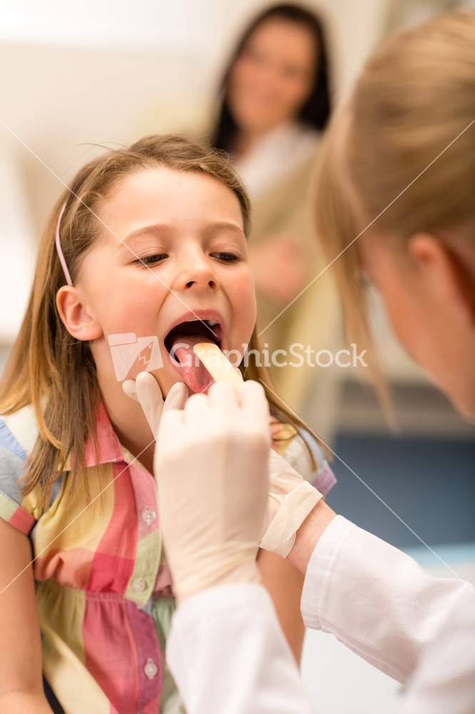 Little girl having throat examination with tongue depressor