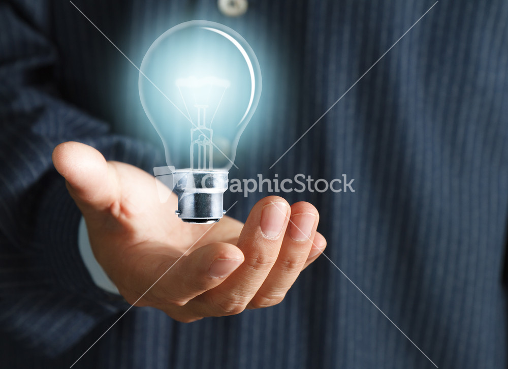 Close Up Of Light Bulb In Hand Of Businessman