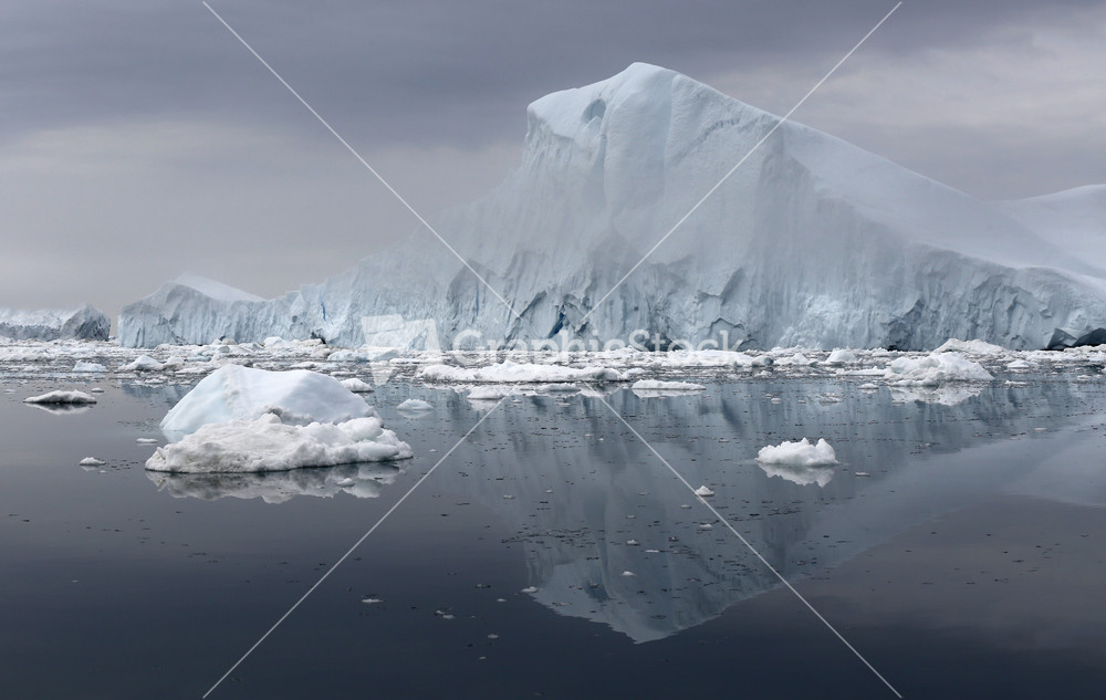 Icebergs and ice floes under a grey sky