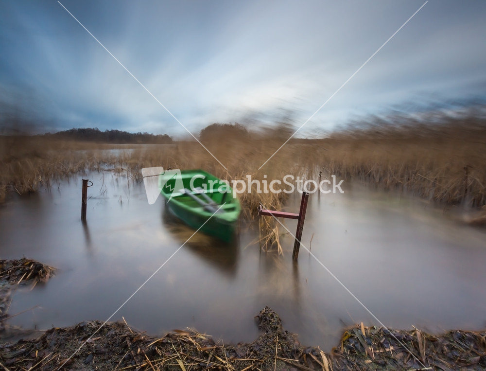 Lake with boat. long exposure landscape. Autumnal bad weather landscape photographed on polish lake.--